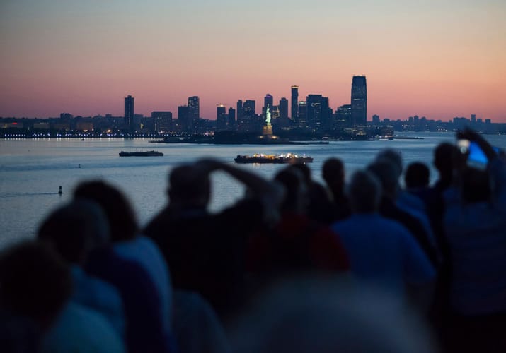 Passagerer der nyder udsigten over New York fra krydstogtskibets dæk