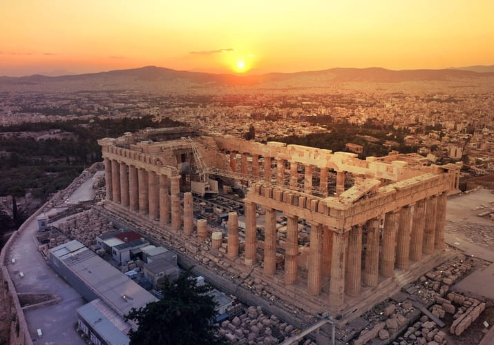 Akropolis og Parthenon i Athen set fra luften i solnedgang med storbyen bredt ud omkring
