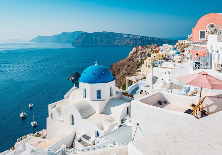Oia p&aring; Santorini med hvide huse og bl&aring; kupler h&oslash;jt over calderaen i Det &AElig;g&aelig;iske Hav