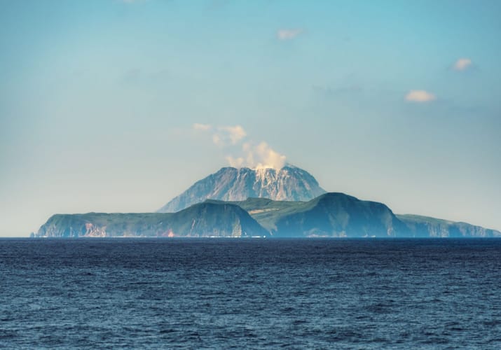 Aktiv vulkan p&aring; Kagoshima-&oslash;en set fra havet med r&oslash;g og damp