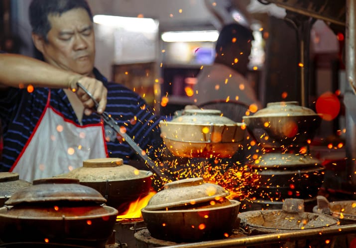 Asiatisk gadek&oslash;kken med chef der laver mad og spektakul&aelig;re ildgnister fra wok