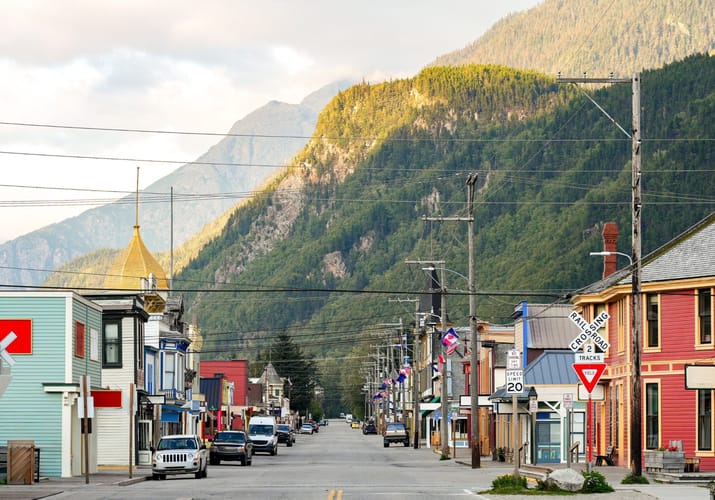 Hovedgaden i historiske guldgraverbyen Skagway med farverige tr&aelig;huse og bjerglandskab i Alaska